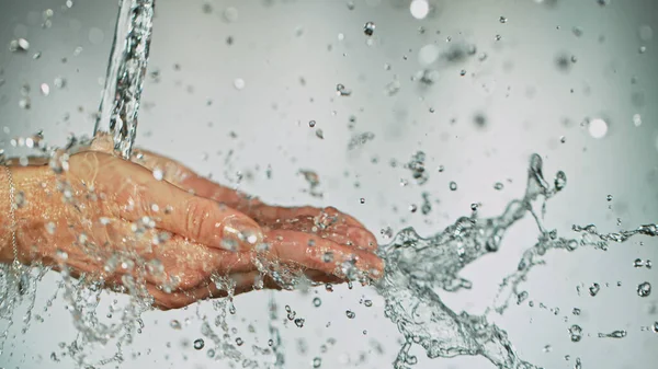 Primer plano de las manos femeninas bajo el chorro de agua salpicada —  Fotos de Stock