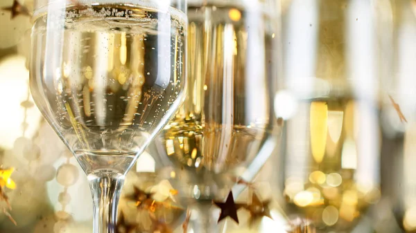 Par de flautas de champanhe com bolhas em fundo de luz dourada — Fotografia de Stock