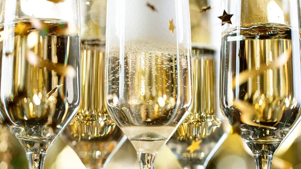 Champagne flöjter med bubblor på gyllene ljus bakgrund — Stockfoto
