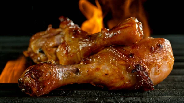 Sabrosas patas de pollo en rejilla de hierro fundido con llamas de fuego. — Foto de Stock