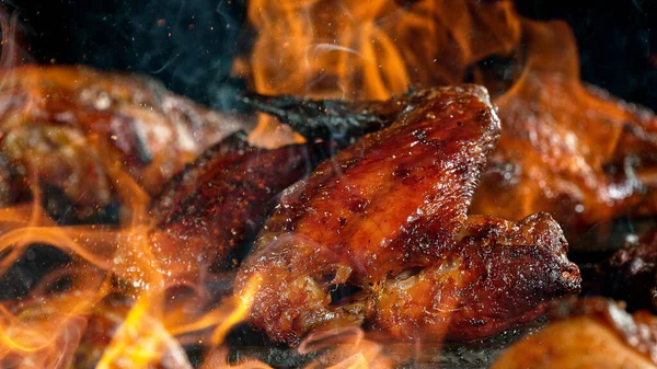 Pernas de frango saborosas na grelha de ferro fundido com chamas de fogo. — Fotografia de Stock
