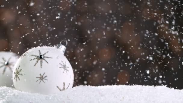 Bodegón de Navidad con luces desenfocadas en el fondo y copos de nieve cayendo. Super cámara lenta. — Vídeos de Stock