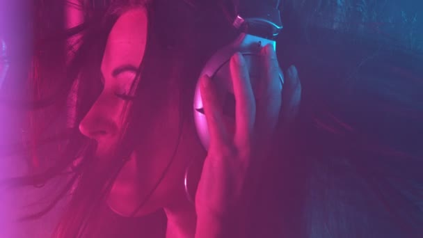 Portrait of Brunette Girl Listening to Music in Earphones and Dancing on Party. — Stock Video