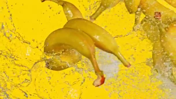 Super slow motion av bananer slå i luften på gul bakgrund. — Stockvideo