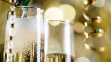 Altın Bokeh 'in arka planında köpüklü şampanya kadehleri.