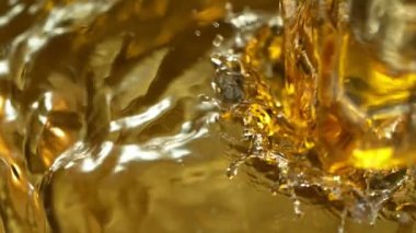 Altın Arkaplan 'a dökülen beyaz şarabın Süper Yavaş Hareket Detaylı Çekimi