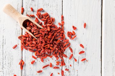 Eski ahşap masada kırmızı goji üzümleri.