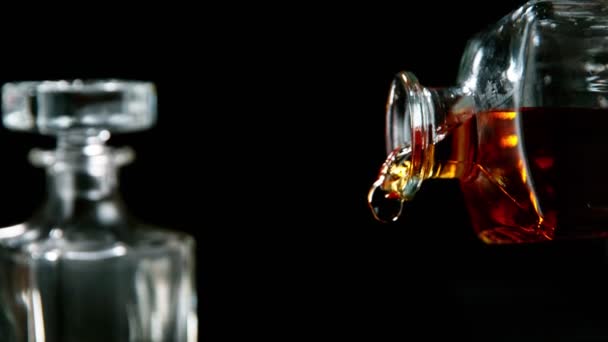 超スローモーションでウイスキーのガラスに落ちる氷のキューブに続くカメラ — ストック動画