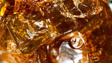 Buz küpü viski bardağına düşüyor.