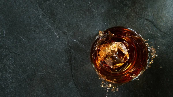 Cubo de hielo cayendo en el vaso de whisky — Foto de Stock