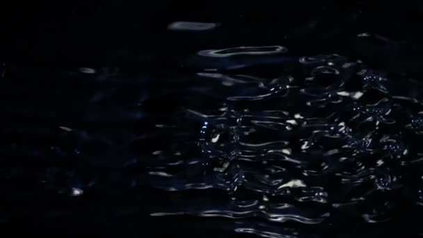 Water spatten op zwarte achtergrond, super slow motion. — Stockvideo