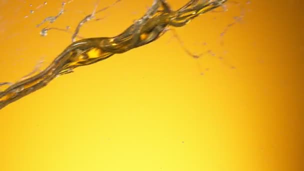 Super Slow Motion Shot of Splashing Oil na złotym tle — Wideo stockowe