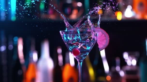 Kamera Följer Iskuber Fallande i glas färsk frukt cocktail i baren. Superlångsamma rörelser. — Stockvideo