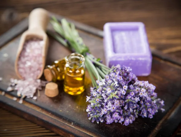 Wellness treatments with lavender flowers on wooden table. — Stock Photo, Image