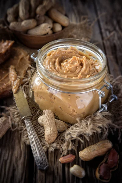Burro di arachidi fresco su terreno di legno — Foto Stock