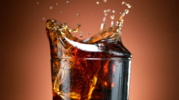 Cola häller i ett glas med isbitar — Stockfoto