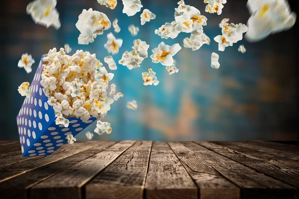 Zwevende popcorn rond een papieren doos. — Stockfoto