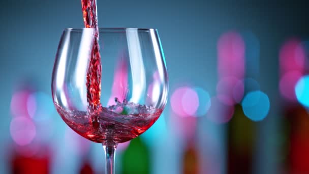 Super langzame beweging van rode wijn gieten in wijnglas in een bar. — Stockvideo