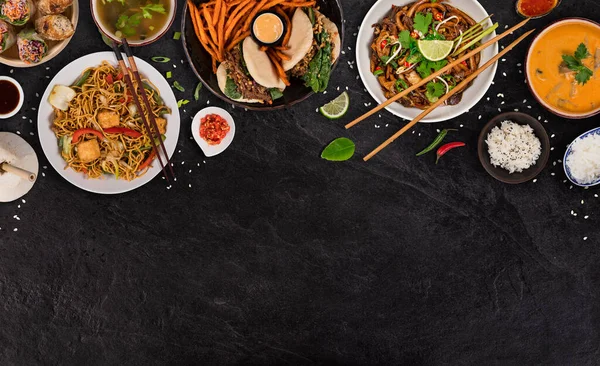 Asiatisches Essen auf schwarzem Steintisch, Draufsicht, Platz für Text. — Stockfoto