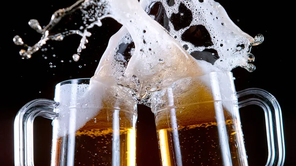 Due bicchieri di birra tostata creando spruzzi. — Foto Stock