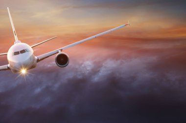 Dramatik bulutların üzerinde uçan ticari uçak..