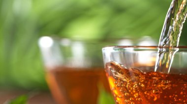 Çay fincanına çay dolduruyorum.