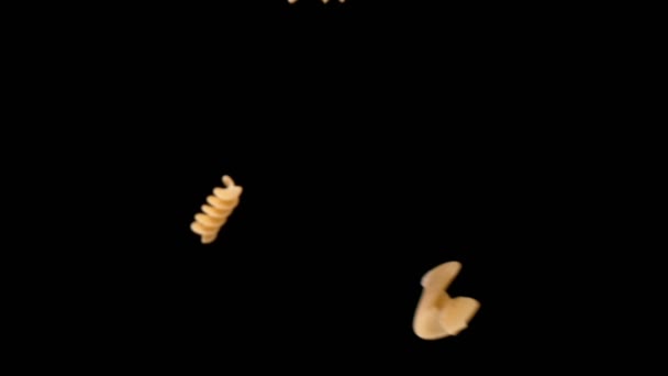 Super slow motion van vliegende ongekookte Italiaanse pasta Fusilli op zwarte achtergrond. — Stockvideo