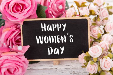 Sevgililer Günü ya da Anneler Günü için küçük bir yazı tahtası. Pembe güllerle arka plan.