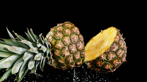 Ananas faller på en svart bakgrund. — Stockfoto