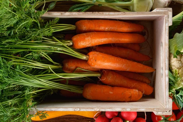 Świeże organiczne marchewki w drewnianym pudełku. — Zdjęcie stockowe