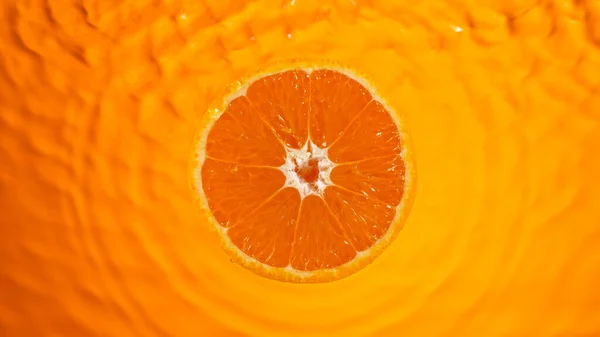 Färsk apelsinskiva faller i stänk vatten stänk — Stockfoto
