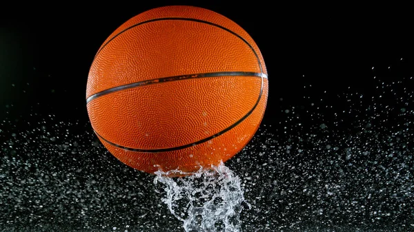 Pallacanestro caduta sulla superficie dell'acqua, sfondo nero. — Foto Stock