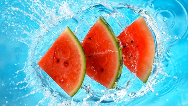 Fresh pieces of water melon falling in water with splash — Stock Photo, Image