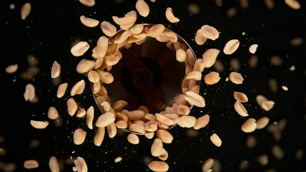 Amendoins rotativos em fundo preto. — Fotografia de Stock