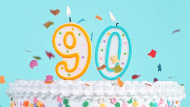 90 numara şeklinde mumları olan renkli, lezzetli bir doğum günü pastası..