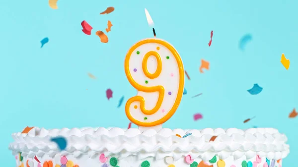 Colorful tasty birthday cake with candles shaped like the number 9. — Stock Photo, Image