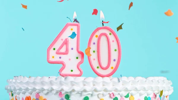 Colorful tasty birthday cake with candles shaped like the number 40.