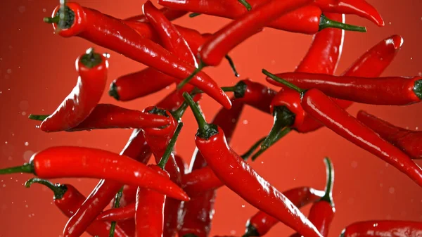 Smaklig varm chili paprika flyger i luften. — Stockfoto