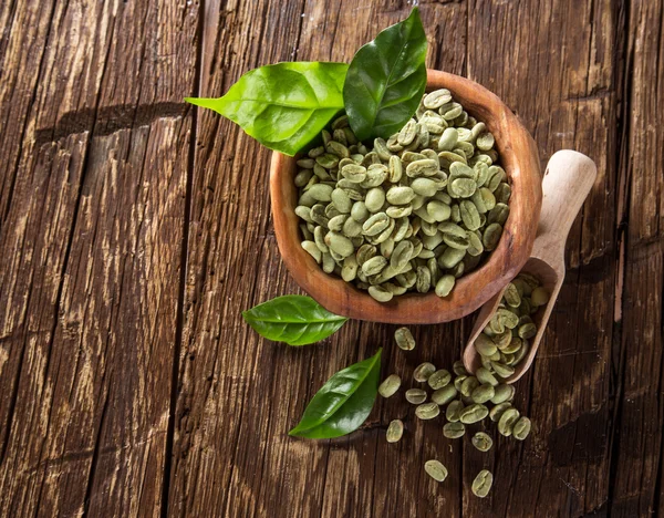 Granos de café verdes en tazón de madera — Foto de Stock