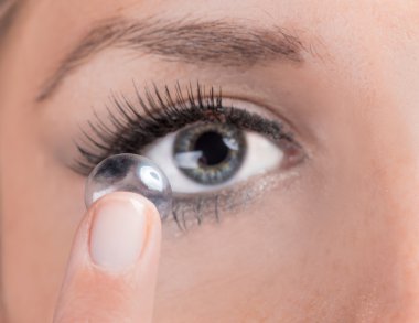 genç kadın bir kontakt lens ekleme