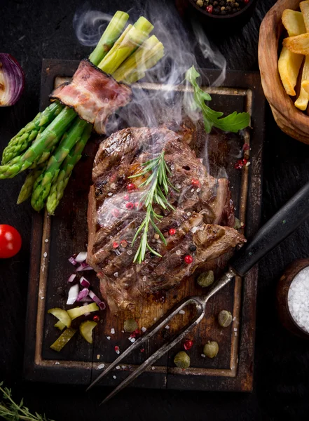 Beef steak on wooden table — Stock Photo, Image