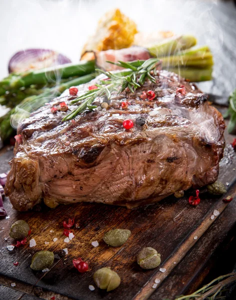 Beef steak on wooden table — Stock Photo, Image