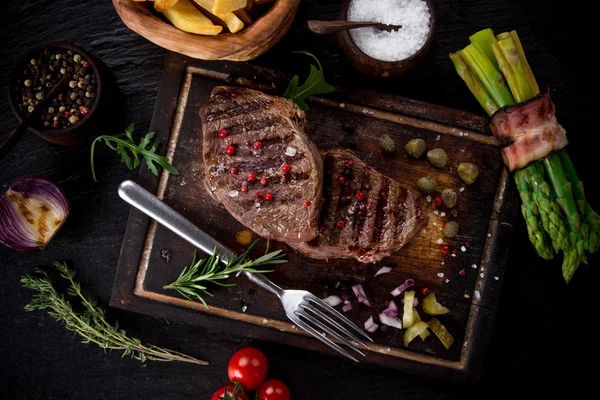 Bife de carne em mesa de madeira — Fotografia de Stock