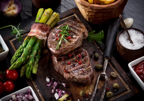 Beef steak on wooden table — Stock Photo, Image