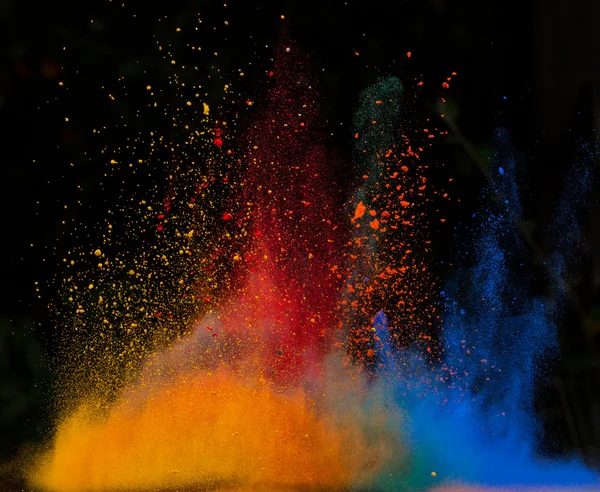 Launched colorful powder over black — Stock Photo, Image