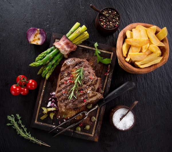 Beef steak on wooden table — Stock Photo, Image