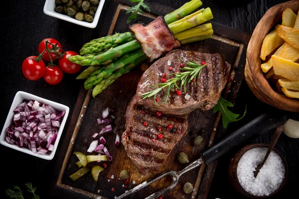 Beef steak on wooden table — Stock Photo, Image