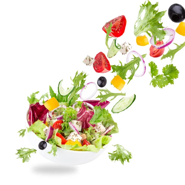 Fresh salad with flying vegetables ingredients Royalty Free Stock Images
