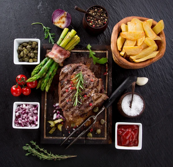 Beef steak on wooden table — Stock Photo, Image