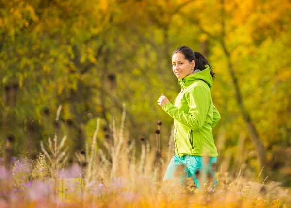 Junge brünette Frau läuft in Park. — Stockfoto